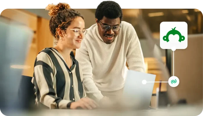 Two colleagues looking at a laptop screen with a SurveyMonkey integration icon overlay.