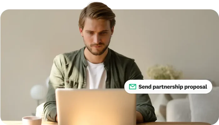 Man working at a laptop with a "Send partnership proposal" icon overlay.