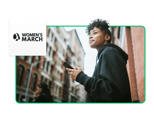 woman in city setting, holding cell phone, with floating Women's March logo