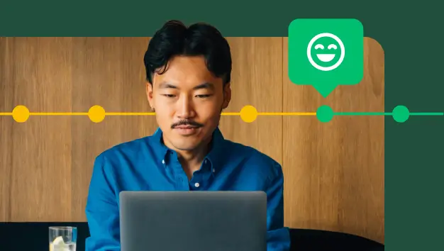 Man typing on laptop, next to smiling emoji