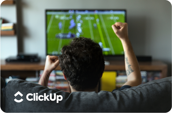 a man watching sports on the tv with clickup logo