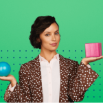 Woman holding a blue sphere in one hand and a pink block in the other