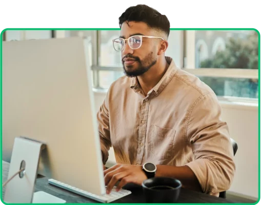 Homem sentado e trabalhando no computador próximo a janela