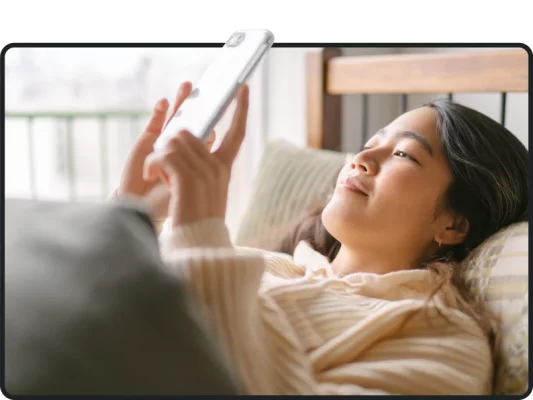 Woman lying in bed starting at phone