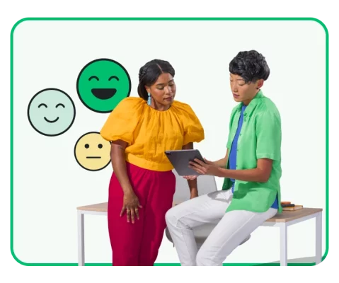 Two people looking at a tablet screen next to smiling emojis