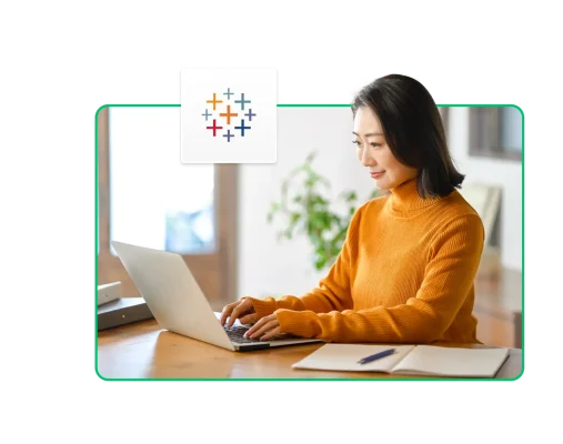 一名女性在筆電前工作,旁邊有 Tableau 的圖示