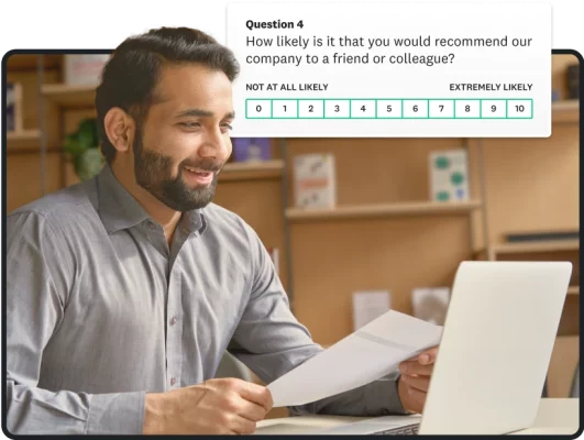 Smiling man looking at laptop screen next to survey question about whether user would recommend company to a colleague