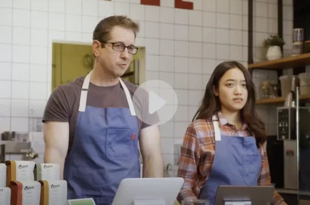 Two confused baristas standing at a register