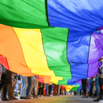 Group holding an LGBTQ flag