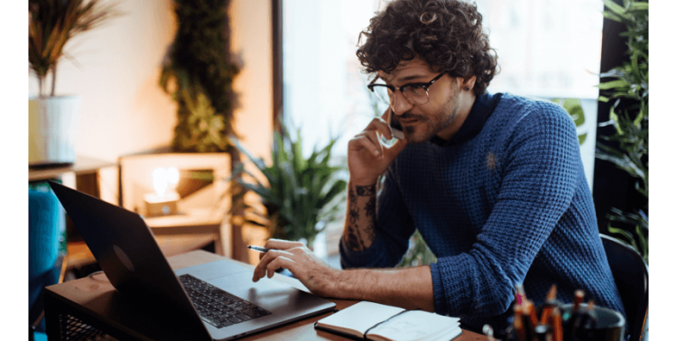 Man talking on phone at his computer