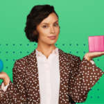 Nainen pitelee yhdessä kädessä pinkkiä kuutiota ja toisessa sinistä palloa