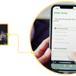 Hands holding a smartphone answering a survey with images of men and women playing video games next to it