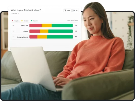 Woman sitting with open laptop next to metrics from a survey