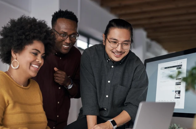 Group of three people looking at a computer screen
