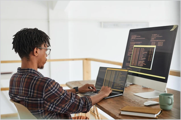 Man sitting at computer writing code