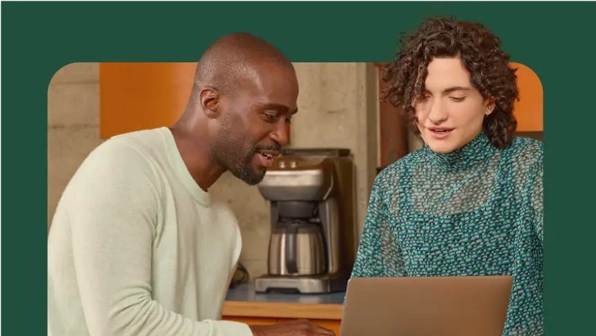 two people collaborating in front of a laptop