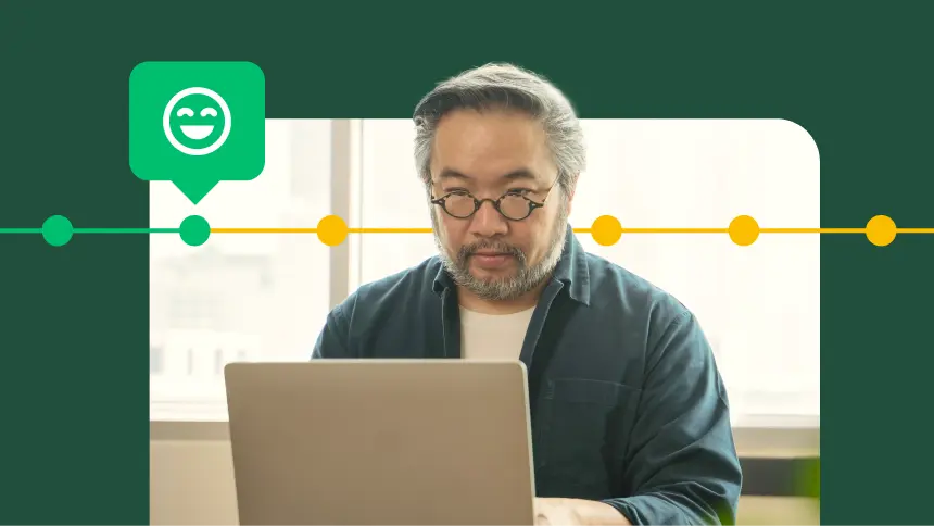 Man typing on a laptop, next to happy face emoji