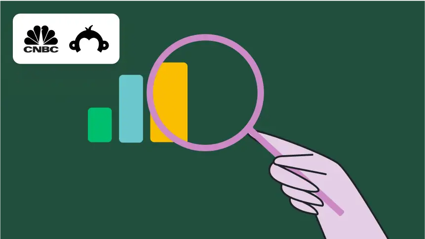 Hand holding magnifying glass over bar graph