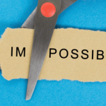 Scissors cutting the word impossible