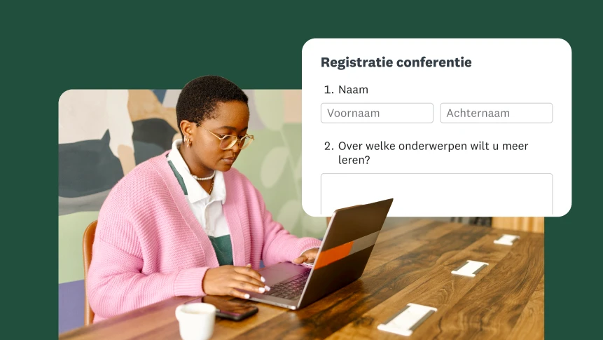 Een persoon aan een bureau die een registratieformulier voor een conferentie invult op een laptop.