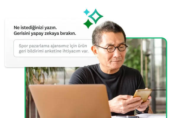 Telefonda bir şeyler yazan bir kişi ve yanında, otomatik olarak oluşturulan bir anket elde etmesi için kullanıcıdan bir istek metni yazmasını isteyen SurveyMonkey Genius'un ekran görüntüsü
