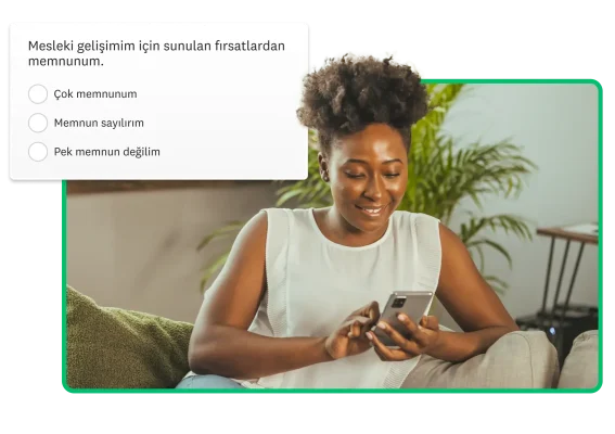 cep telefonuna bakan bir kadın ve arkasında mesleki gelişim anketi ekran görüntüsü