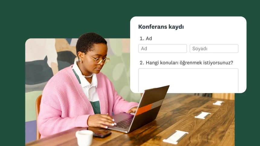 Bir masada oturmuş dizüstü bilgisayarında konferans kayıt formu dolduran bir kişi.