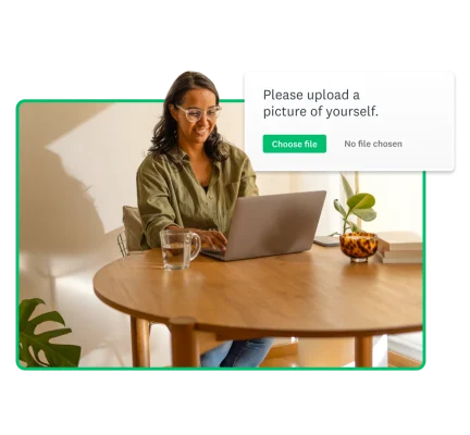 A woman working on a laptop; next to her is a screenshot showing the instruction “Please upload a picture of yourself.”, and the ‘Choose file’ option is selected.