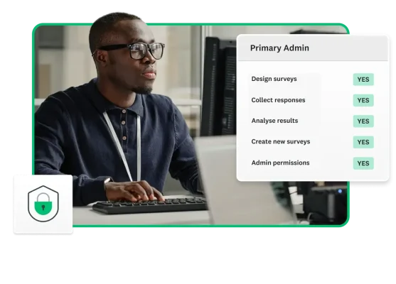 Man working on a computer next to table showing primary admin role user settings