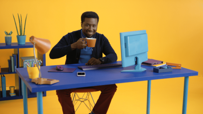 Employee drinking a cup of coffee at his workplace