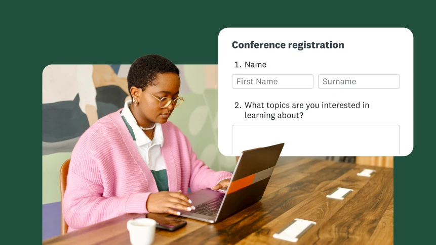 A person sitting at a desk and filling out a conference registration form on a laptop