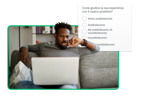 Uomo seduto sul divano davanti al computer, con accanto la schermata di una domanda su un prodotto