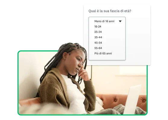 Donna che guarda lo schermo del laptop con espressione concentrata, accanto alla schermata di una domanda demografica che chiede la fascia d'età