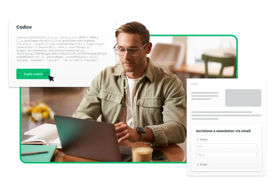 Uomo seduto davanti a un computer portatile con schermate di SurveyMonkey che lo circondano