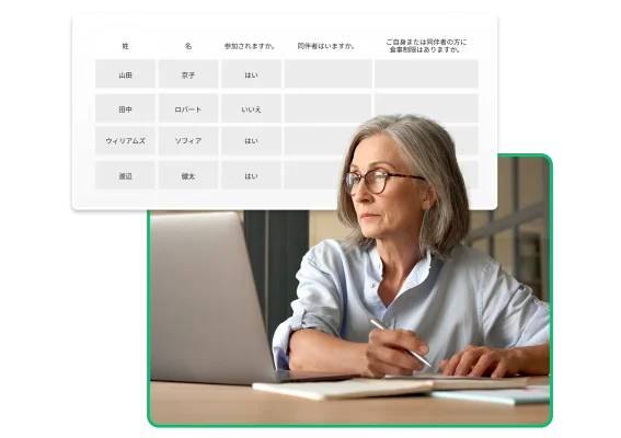 ペンを手に、SurveyMonkeyのイベント出欠アンケートを見ている眼鏡をかけた女性