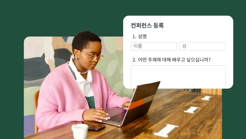 책상에서 노트북으로 컨퍼런스 등록 양식을 작성 중인 사람.