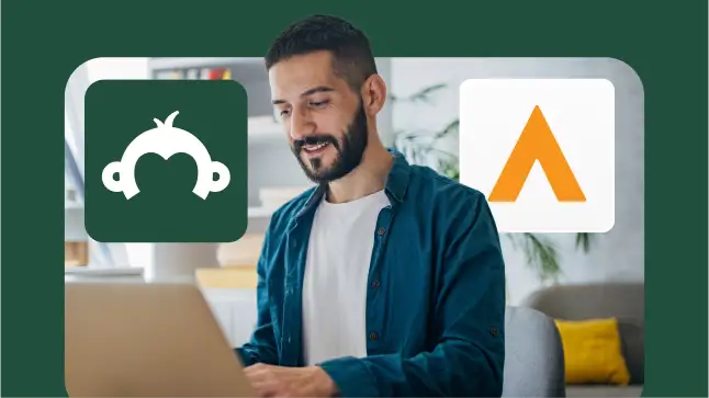 A man smiling and working on his laptop with the SurveyMonkey and Alchemer logos floating in the foreground