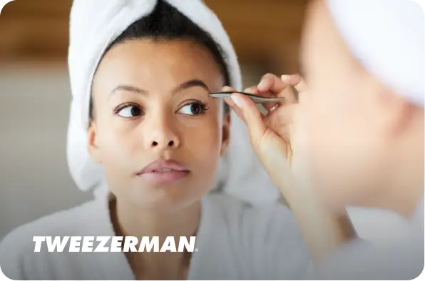 Woman plucking her eyebrows with Tweezerman logo