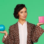 Donna che regge una sfera blu in una mano e un cubo rosa nell'altra