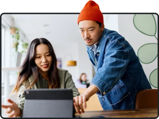 Two people pointing and looking at tablet screen