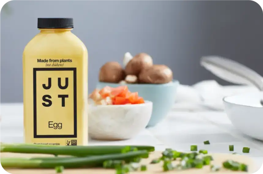 Photo of JUST egg product, next to chopped green onions on a cutting board