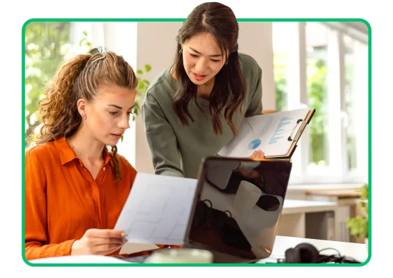 Biri bir belgeyi inceleyen, diğeri de elinde grafiklerin çıktısını tutan iki çalışan