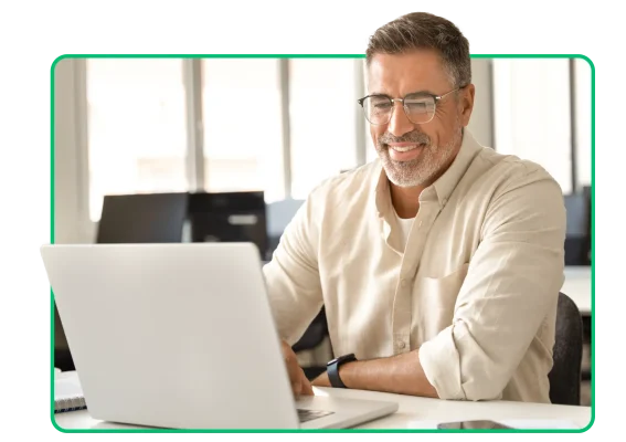 A man sitting at a desk using a laptop
