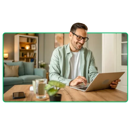 Man som sitter vid ett bord och använder en bärbar dator