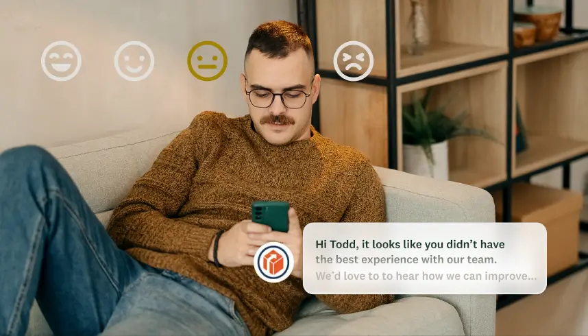 A man looking at his phone with a chat bot message asking for feedback on a negative experience.