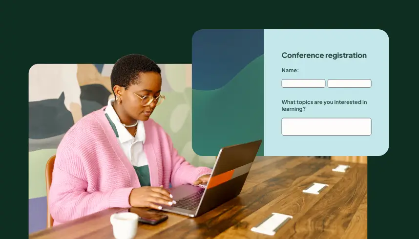 A person at a desk filling out a conference registration form on a laptop
