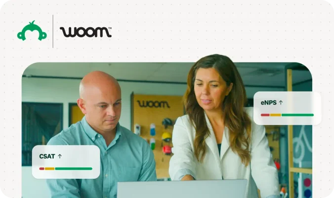 Two colleagues at a laptop reviewing CSAT and eNPS growth graphics for a Woom customer story