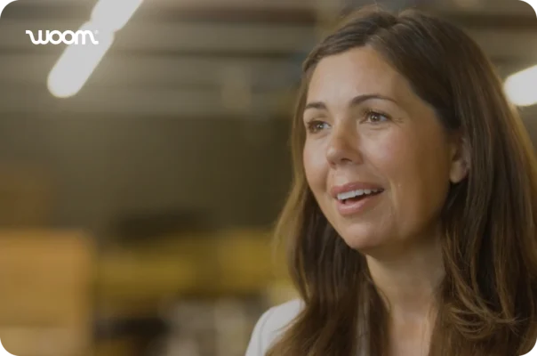 A smiling woman from woom in a customer story video still.