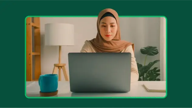 Een vrouw die een hijab draagt en onderzoeksinzichten bekijkt op laptop