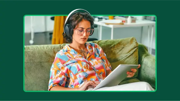 Woman with glasses and headphones scrolling on a tablet